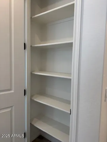 an empty room with wooden floor and a bathroom