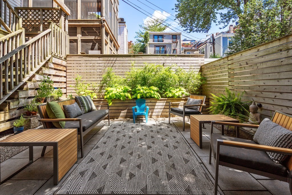 5 Auburn Street, Unit 1 Boston, MA 02129 - Photo 19 of 25 a view of a patio with couches table and chairs and potted plants