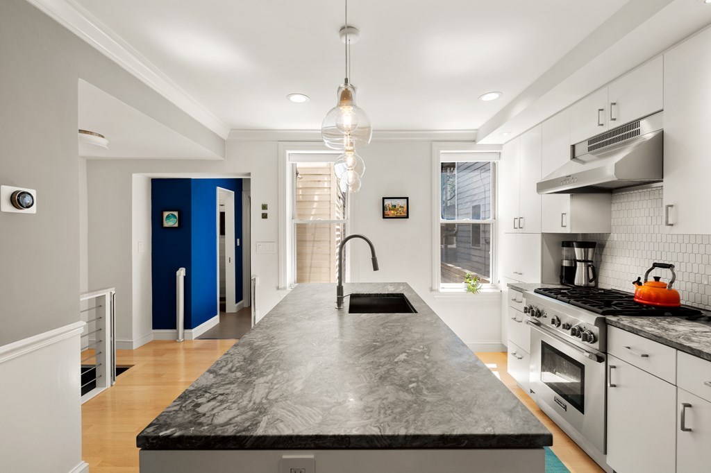 5 Auburn Street, Unit 1 Boston, MA 02129 - Photo 4 of 25 a kitchen with stainless steel appliances granite countertop a sink dishwasher a stove and a refrigerator with wooden floor