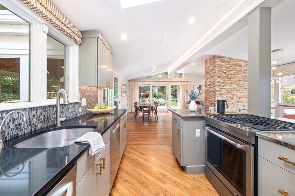 16 Marshall Road Winchester, MA 01890 - Photo 4 of 42 a kitchen with kitchen island granite countertop a sink stove and wooden cabinets