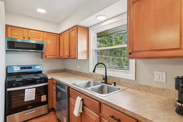 a kitchen with stainless steel appliances a sink a stove a microwave and cabinets