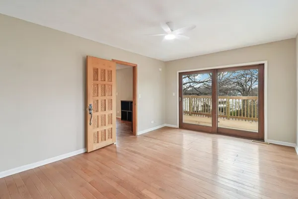 a view of an empty room with glass door and a window