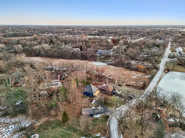 an aerial view of city and lake with trees all around