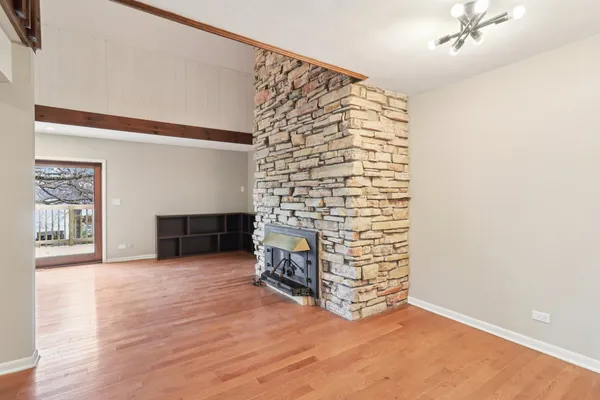 a view of an empty room with a fireplace and cabinet