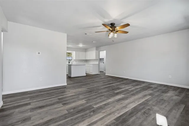 a view of a kitchen with wooden floor and a window