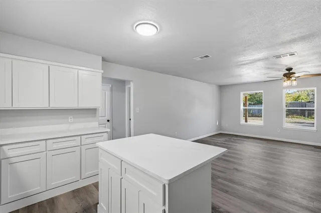 a kitchen with a white cabinets sink and dishwasher with wooden floor