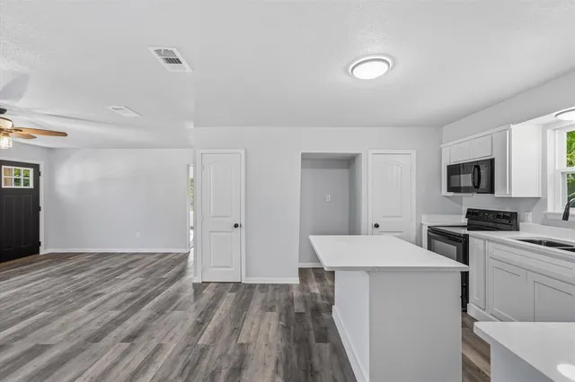 a open kitchen with cabinets a sink and appliances