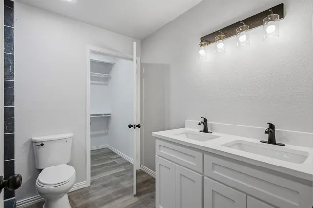 a bathroom with a sink a toilet a mirror and shower