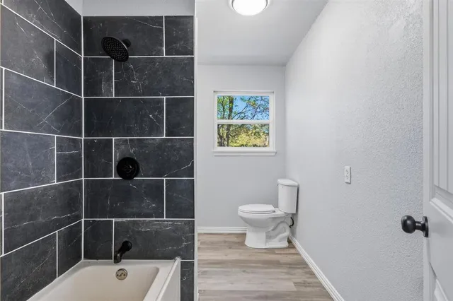 a bathroom with a toilet and a shower