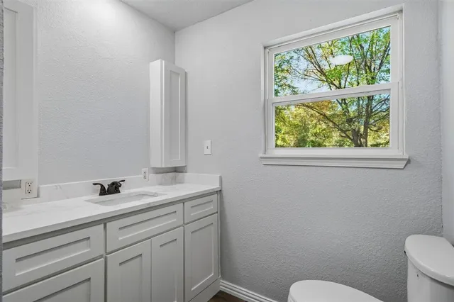 a bathroom with a toilet sink and window