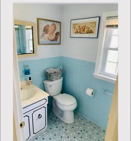 a bathroom with a toilet a sink and a window