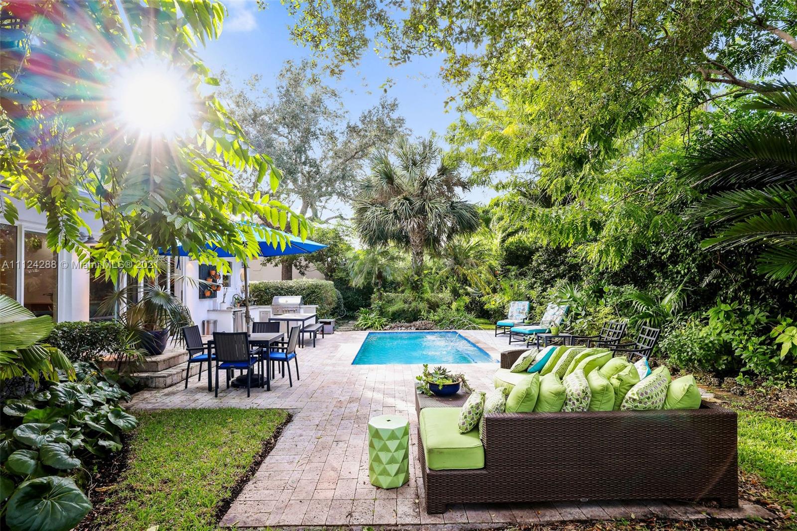 a view of a patio with table and chairs potted plants and large tree