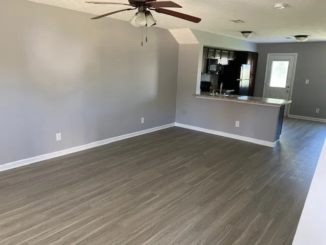 an empty room with wooden floor and cabinet
