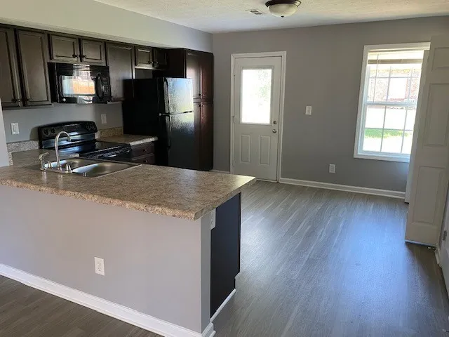 a kitchen with granite countertop a refrigerator and a sink