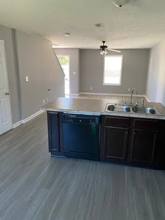 a kitchen with kitchen island granite countertop a sink and wooden cabinets
