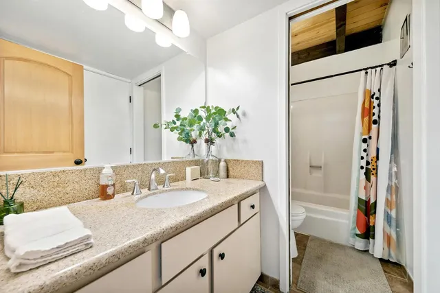 a bathroom with a granite countertop sink and a mirror