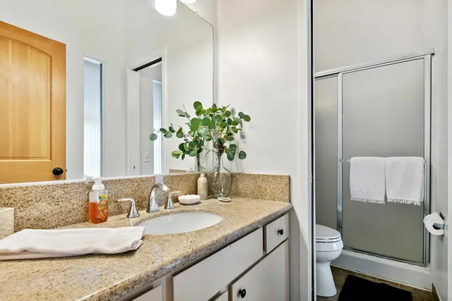 a bathroom with a granite countertop sink and a mirror