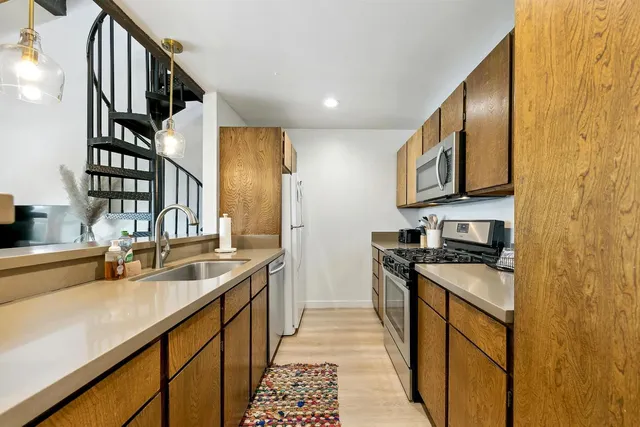 a kitchen with stainless steel appliances granite countertop a sink stove and cabinets