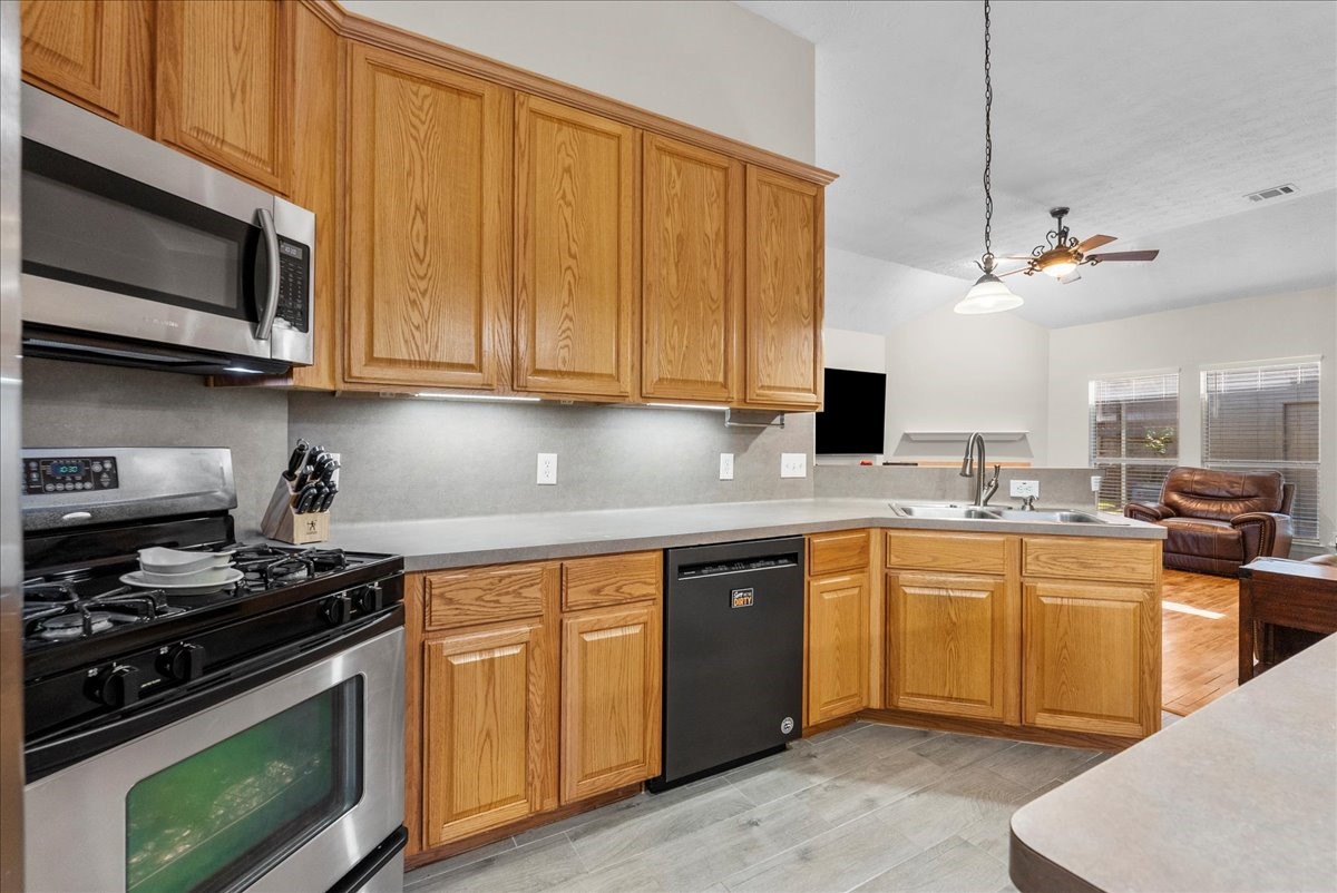 8102 Pinewood Park Humble, TX 77346 - Photo 11 of 37 a kitchen with stainless steel appliances wooden cabinets and a stove top oven