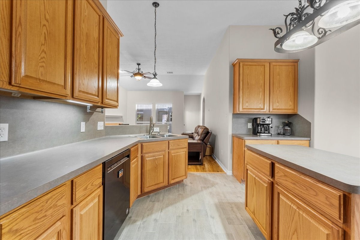 8102 Pinewood Park Humble, TX 77346 - Photo 12 of 37 a kitchen with stainless steel appliances granite countertop a sink a stove cabinets and wooden floor