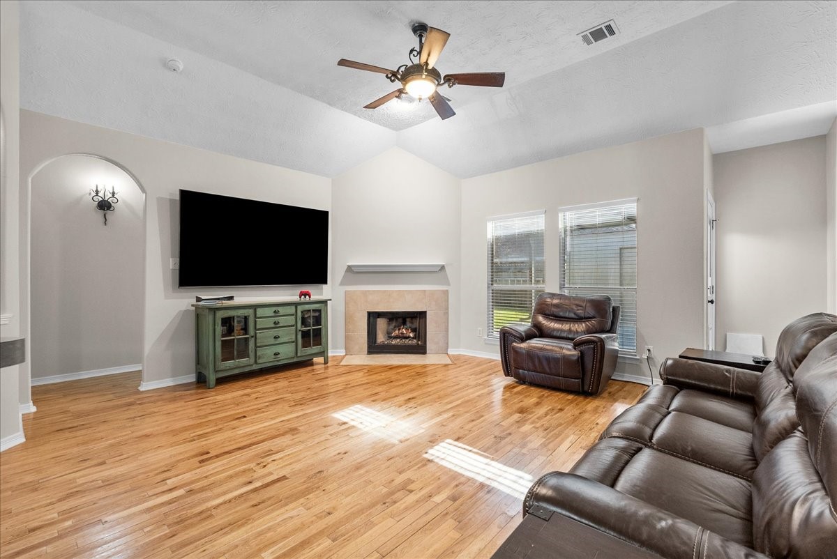 8102 Pinewood Park Humble, TX 77346 - Photo 13 of 37 a living room with furniture a fireplace and a flat screen tv