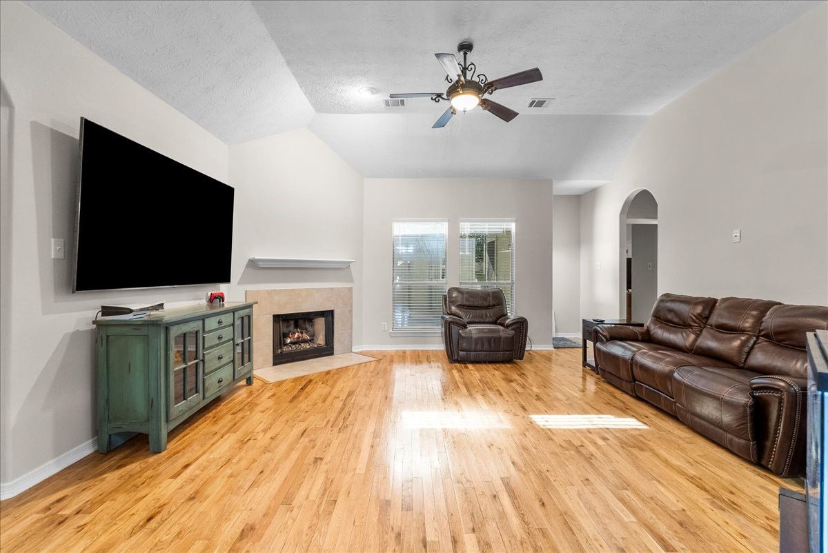 8102 Pinewood Park Humble, TX 77346 - Photo 15 of 37 a living room with furniture a fireplace and a flat screen tv