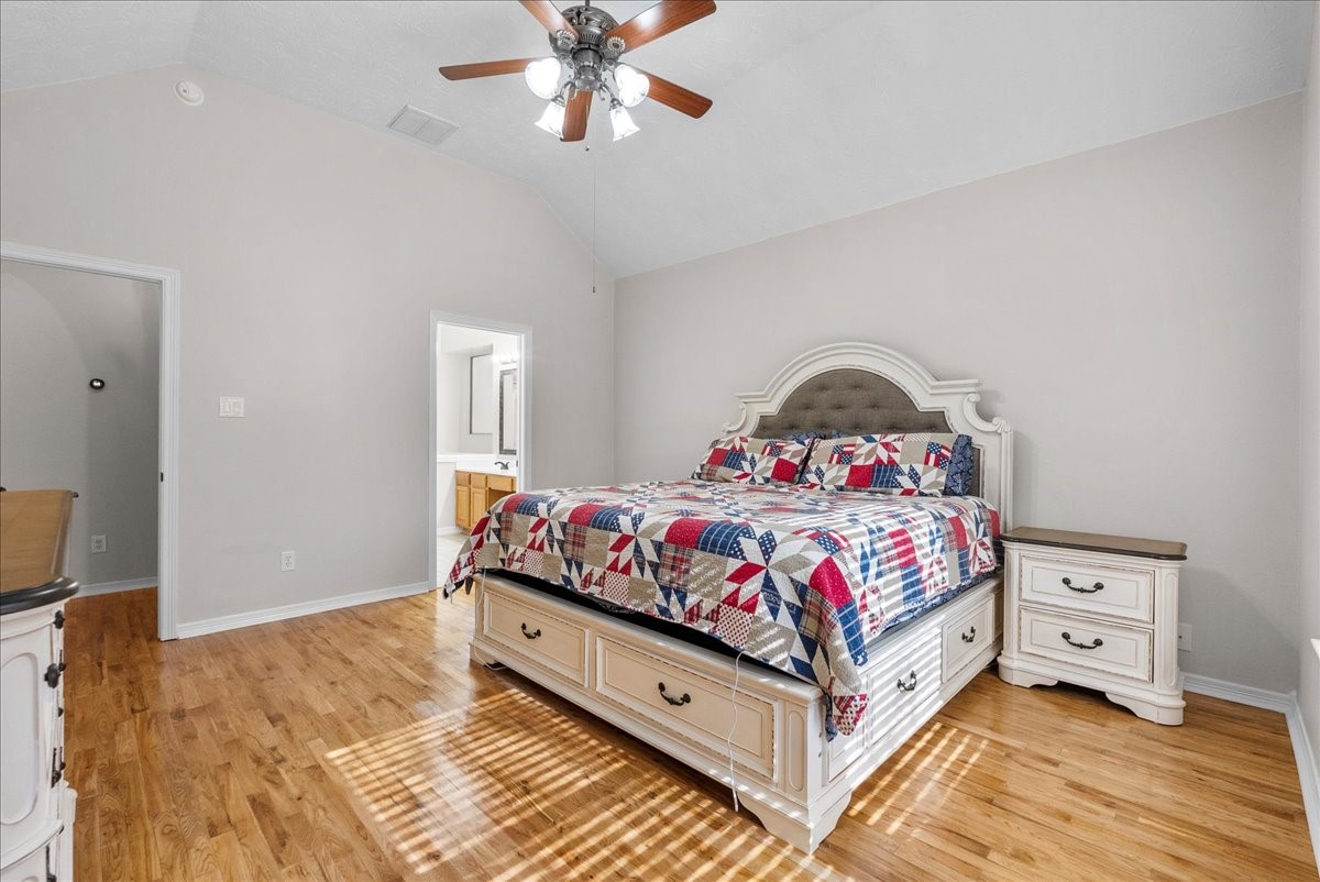 8102 Pinewood Park Humble, TX 77346 - Photo 17 of 37 a bedroom with a bed and a chandelier