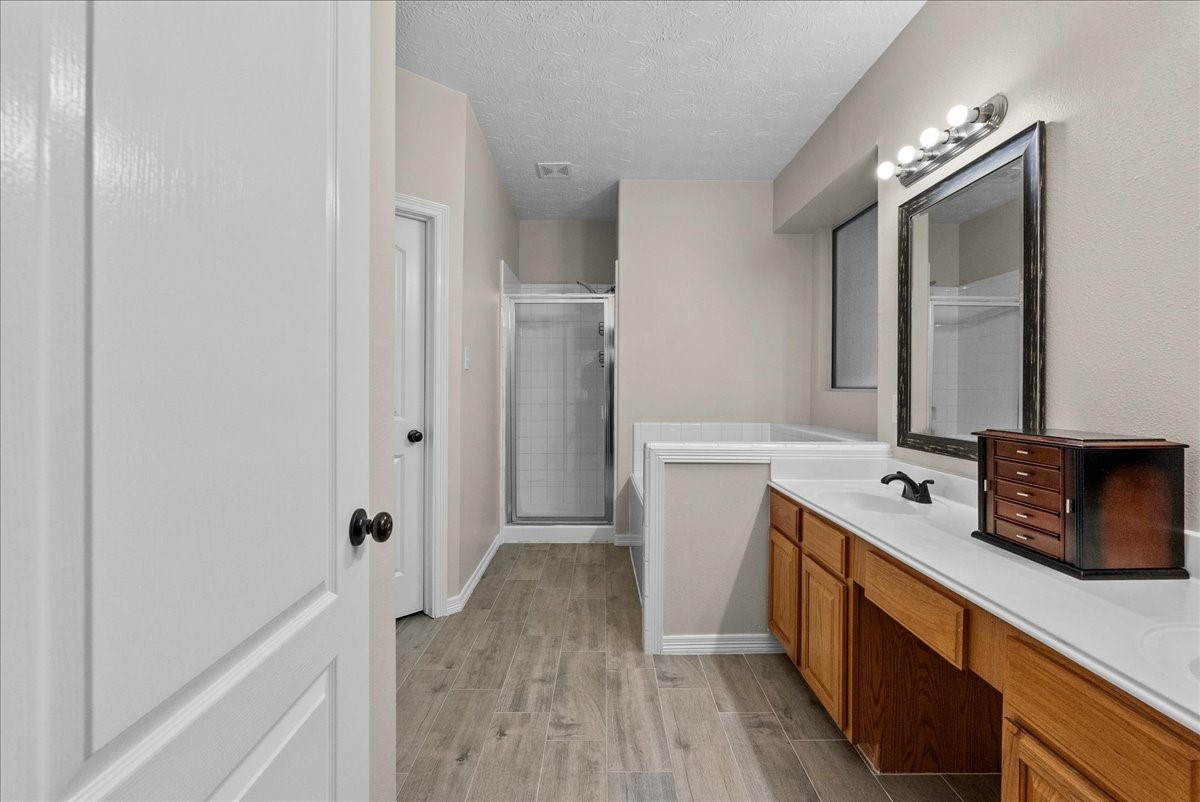 8102 Pinewood Park Humble, TX 77346 - Photo 18 of 37 a spacious bathroom with a double vanity sink a mirror and a bathtub