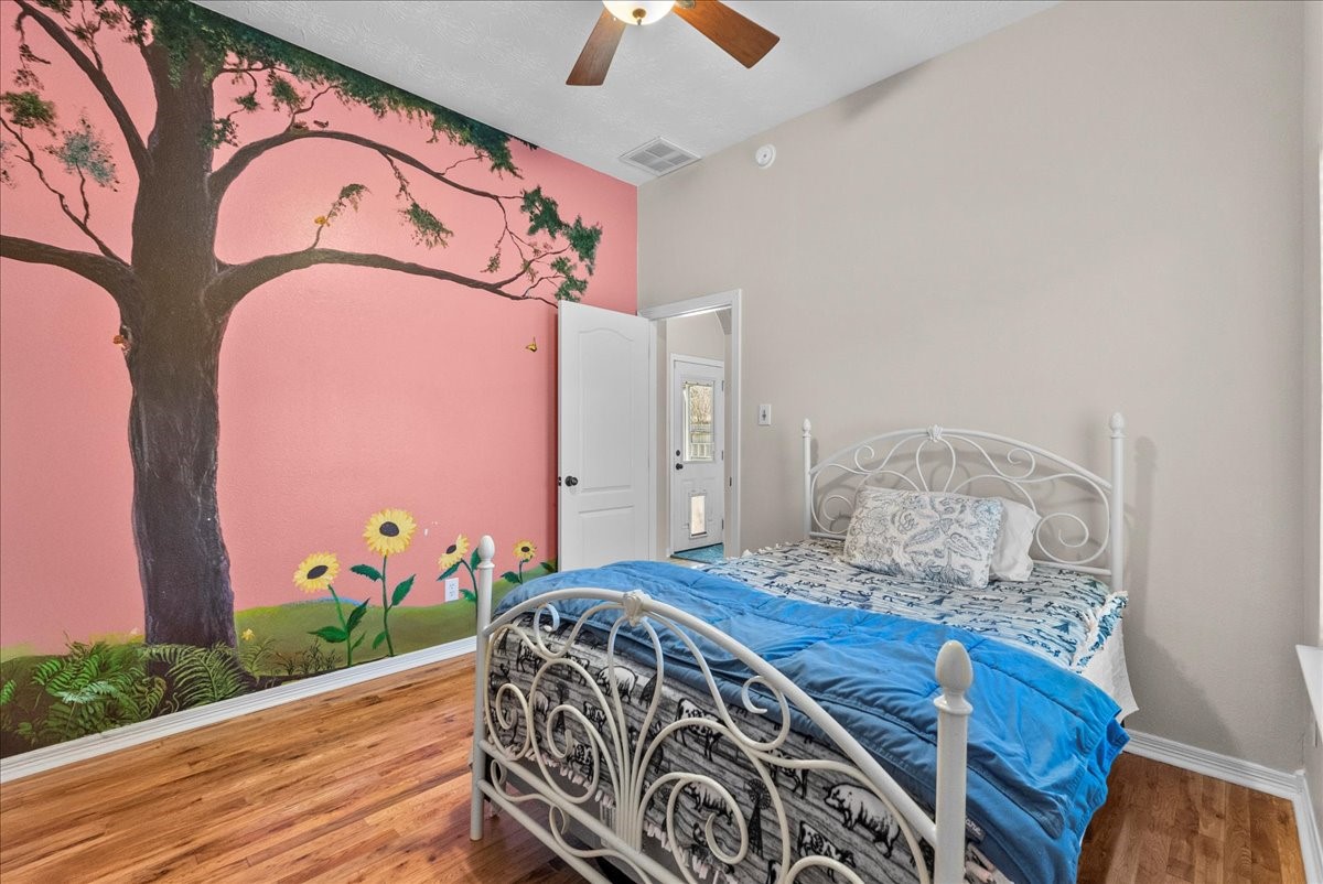 8102 Pinewood Park Humble, TX 77346 - Photo 24 of 37 a bedroom with a bed and a chandelier