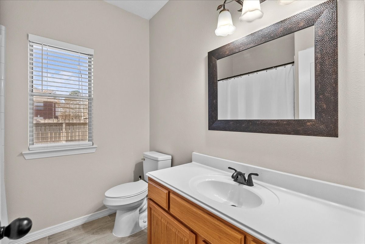8102 Pinewood Park Humble, TX 77346 - Photo 25 of 37 a bathroom with a sink a toilet and mirror