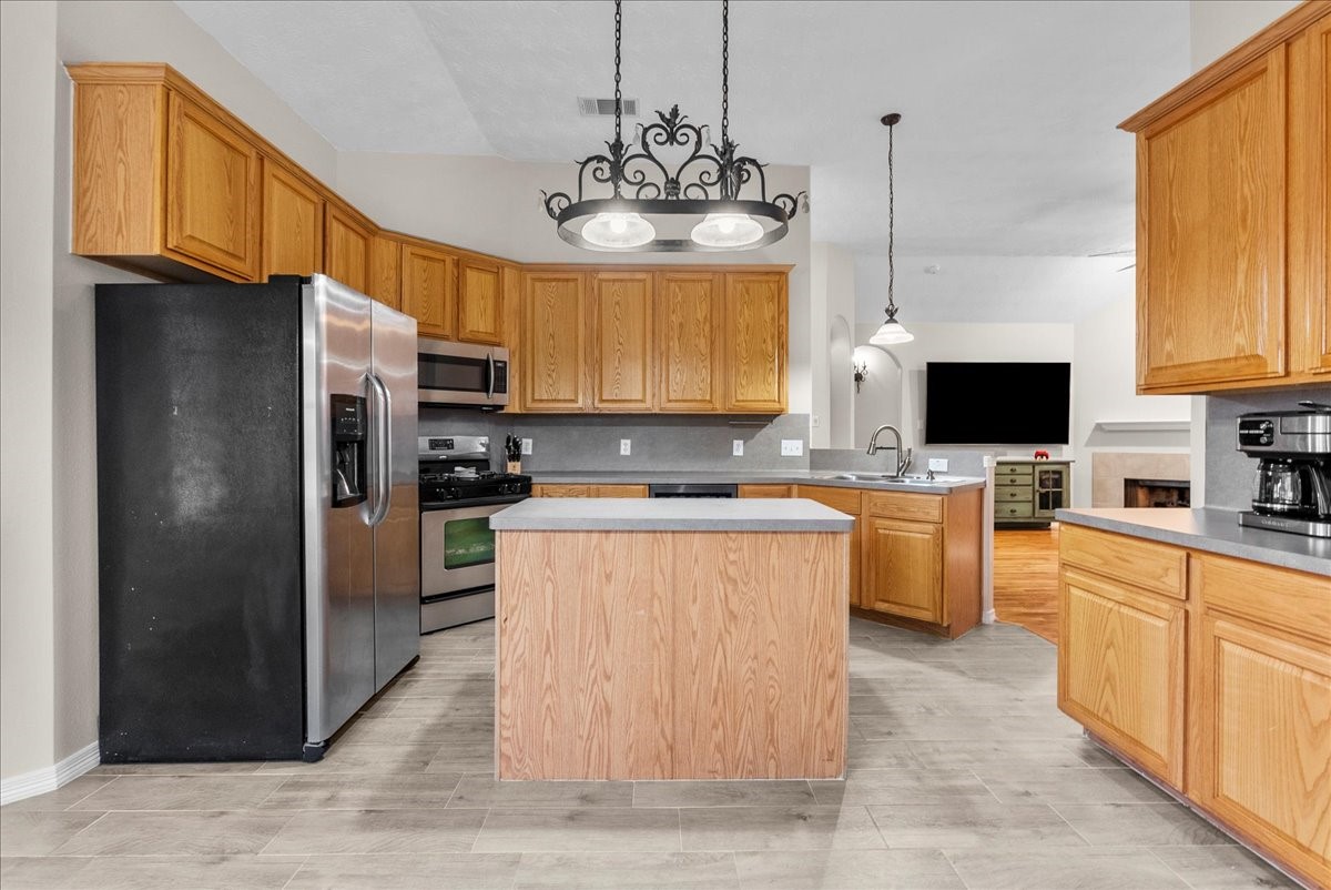 8102 Pinewood Park Humble, TX 77346 - Photo 9 of 37 a kitchen with stainless steel appliances granite countertop a refrigerator a sink dishwasher a oven with a dining table and chairs