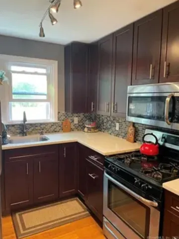 a kitchen with granite countertop wooden cabinets and stainless steel appliances