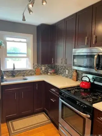 a kitchen with granite countertop wooden cabinets and stainless steel appliances