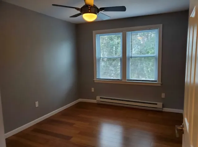 a view of a room with wooden floor and windows
