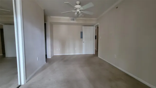 an empty room with a ceiling fan and a window