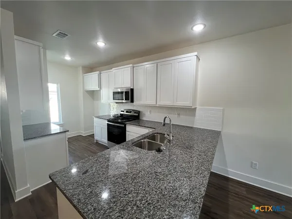 a kitchen with sink and cabinets