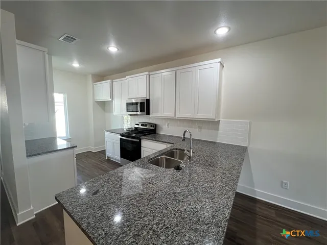 a kitchen with sink and cabinets