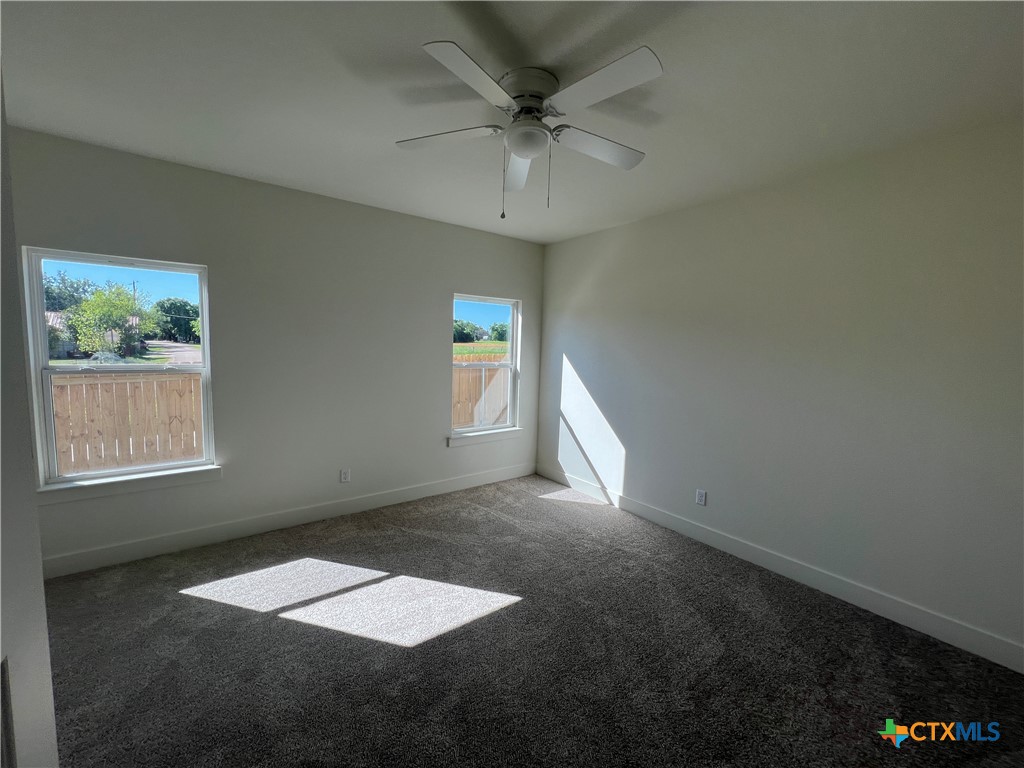 1810 Royal Loop Belton, TX 76513 - Photo 8 of 23 en empty room with windows and ceiling fan
