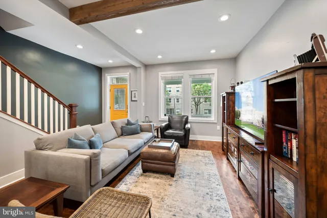 a living room with furniture flat screen tv and a window