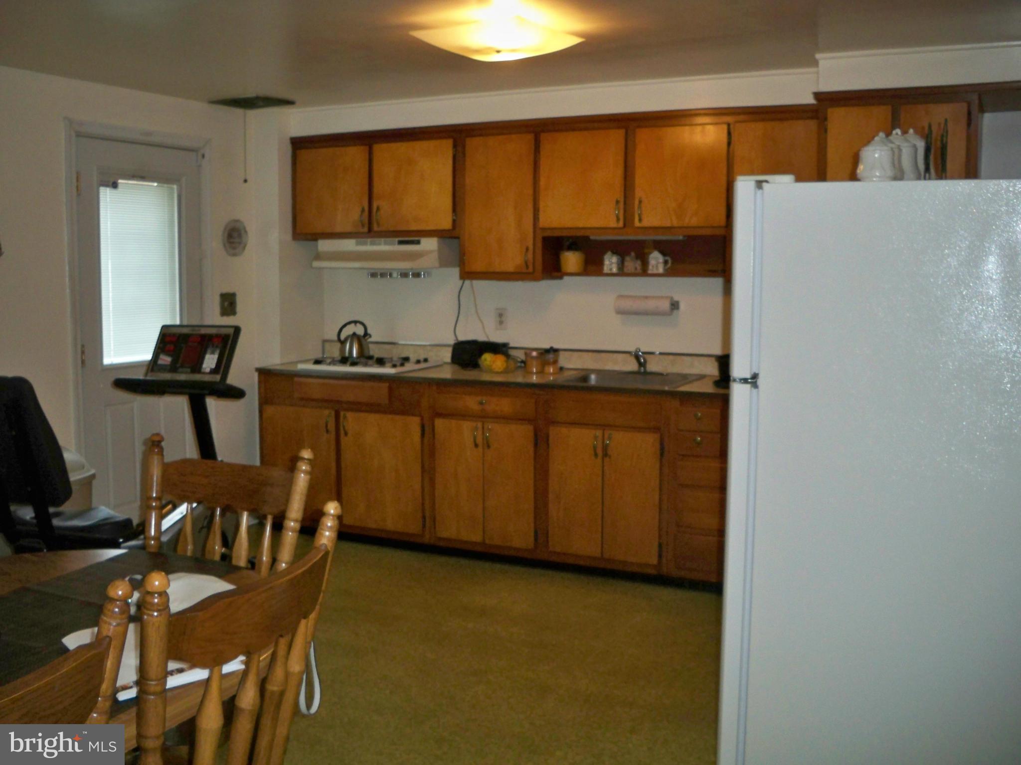 1338 Halstead Road Baltimore, MD 21234 - Photo 8 of 22 a kitchen with a table chairs and a refrigerator