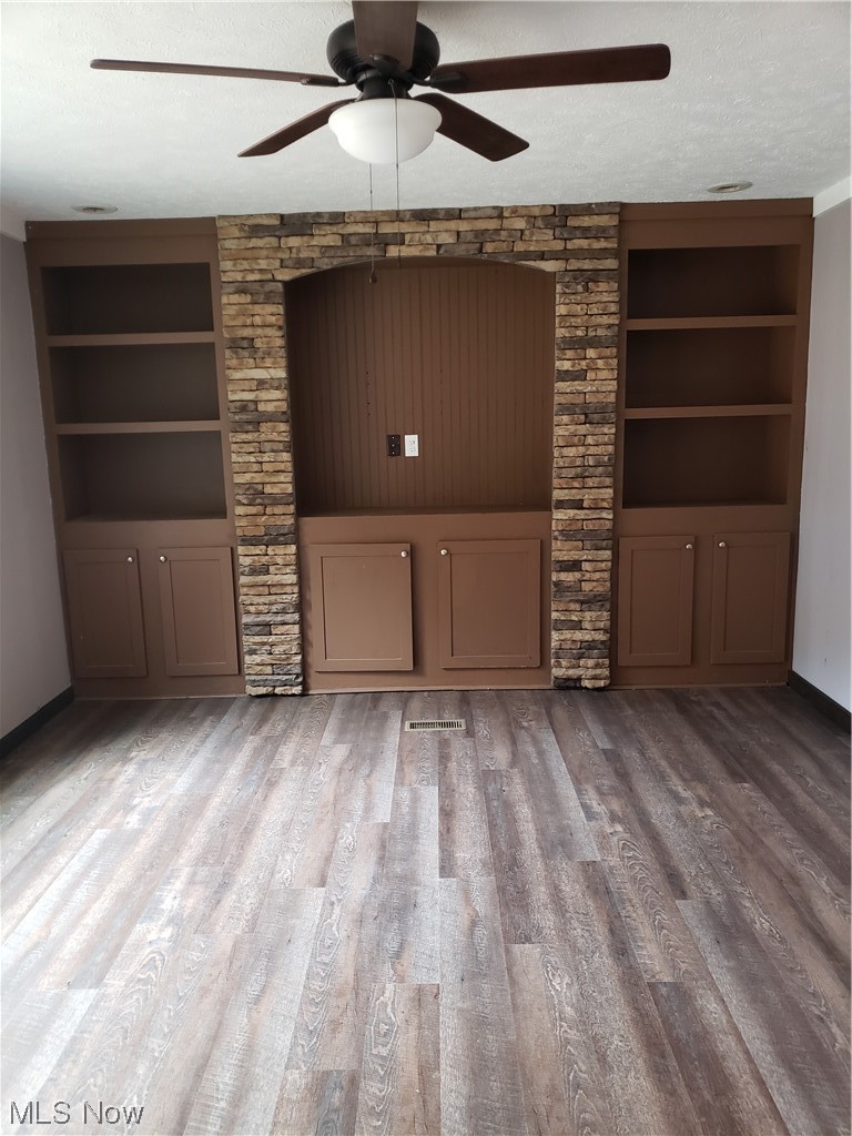 2768 Liverpool Road Le Roy, WV 25252 - Photo 4 of 18 Unfurnished living room featuring ceiling fan, hardwood / wood-style flooring, a textured ceiling, and built in features