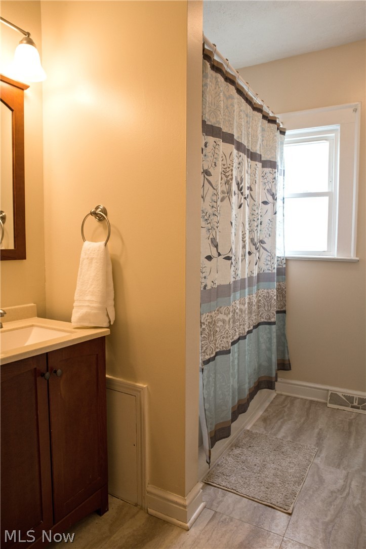 3436 Berea Road Cleveland, OH 44111 - Photo 13 of 26 The bathroom has newer vanity, mirror, fixture and flooring. Full sized tub and shower and newer light and towel fixtures.