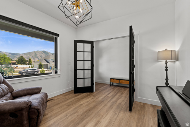 3111 South 1250 West Logan, UT 84321 - Photo 4 of 51 Spacious room featuring a large window, mountain scenery, light wood-finish flooring, and a modern geometric light fixture