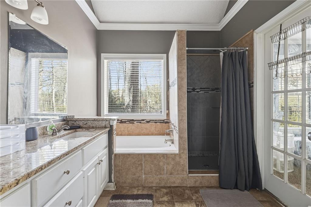 355 Radcliffe Trace Covington, GA 30016 - Photo 13 of 28 a bathroom with a granite countertop sink and a bathtub