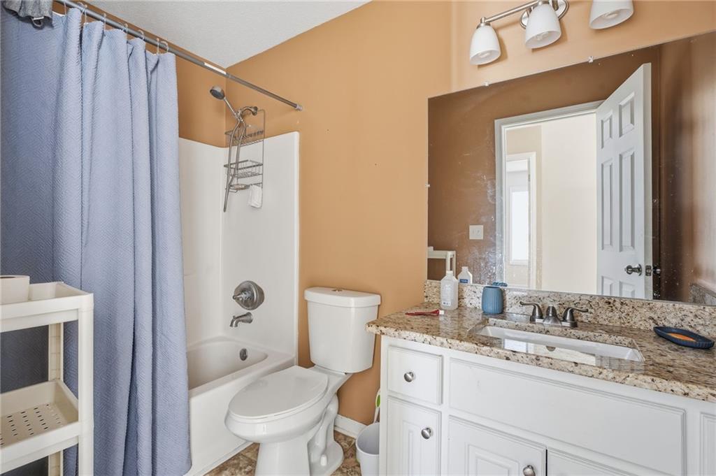 355 Radcliffe Trace Covington, GA 30016 - Photo 25 of 28 a bathroom with a granite countertop sink toilet and shower