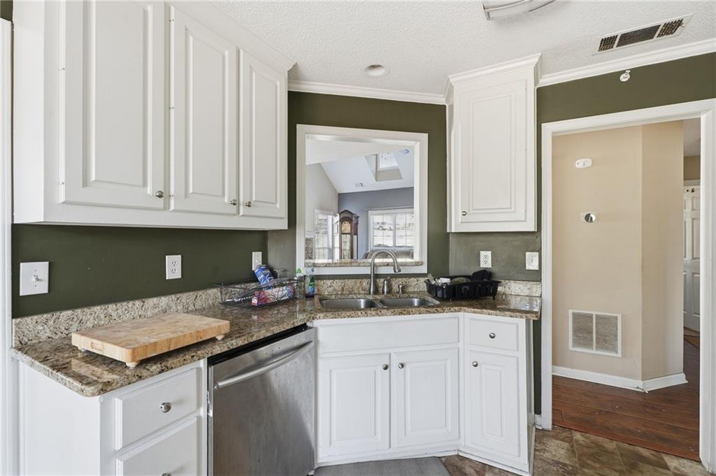355 Radcliffe Trace Covington, GA 30016 - Photo 8 of 28 a kitchen with stainless steel appliances granite countertop a sink and cabinets