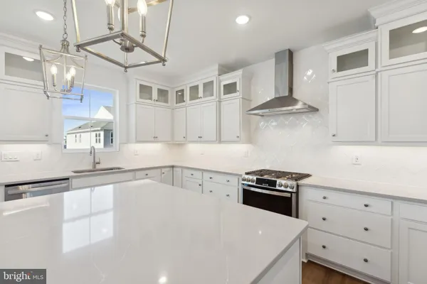 a kitchen with granite countertop a sink a stove and cabinets