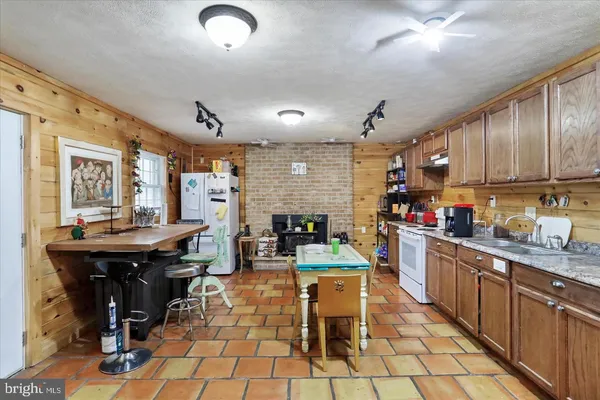 a kitchen with stainless steel appliances granite countertop a sink a stove and a refrigerator