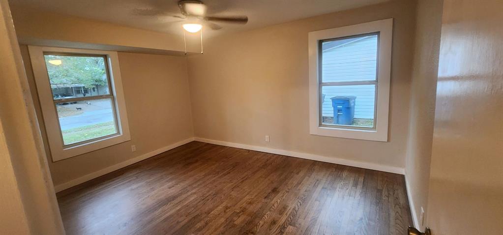 7342 Amy Street Dallas, TX 75217 - Photo 3 of 7 a view of an empty room with wooden floor and a window