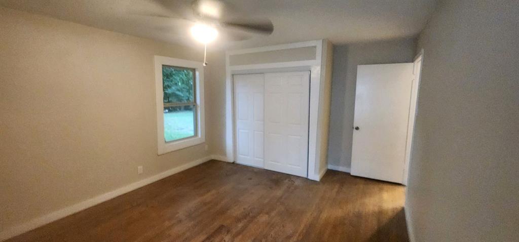 7342 Amy Street Dallas, TX 75217 - Photo 4 of 7 an empty room with wooden floor and windows